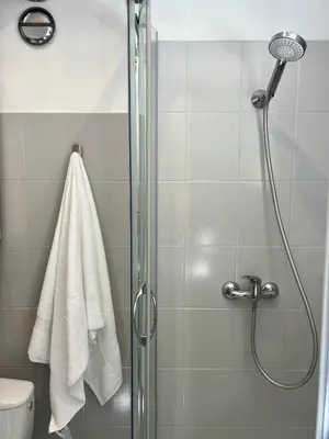 a bathroom with a shower with a glass door at Tomasza Street Main Square Apartment in Kraków
