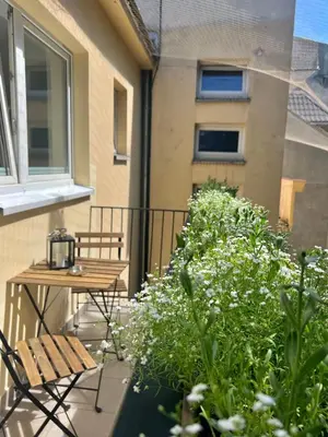 a balcony with a table and chairs and plants at Tomasza Street Main Square Apartment in Kraków