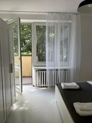 a bedroom with a bed and a large window at Tomasza Street Main Square Apartment in Kraków