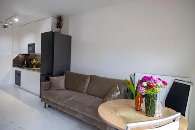 a living room with a couch and a table with flowers at Imperial Citi Yes Apartament in Kraków