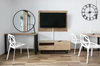 a living room with two white chairs and a mirror at Luxury Apartment Zablocie WiFi Air Conditioning in Kraków