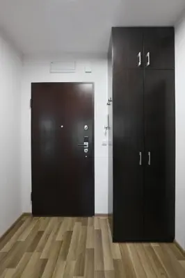 a large black door in a room with wooden floors at Luxury Apartment Zablocie WiFi Air Conditioning in Kraków