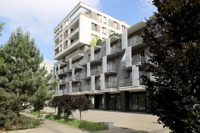 a white apartment building with trees in front of it at Luxury Apartment Zablocie WiFi Air Conditioning in Kraków