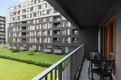 a balcony of an apartment building with a grassy yard at Luxury Apartment Zablocie WiFi Air Conditioning in Kraków