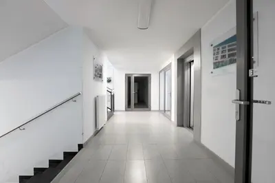 a hallway of a building with white walls and stairs at Luxury Apartment Zablocie WiFi Air Conditioning in Kraków