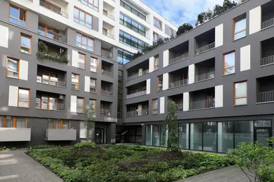 an apartment building with a garden in front of it at Luxury Apartment Zablocie WiFi Air Conditioning in Kraków