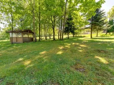 a gazebo in the middle of a field with trees at Apartment Marcyporęba by Interhome in Marcyporęba
