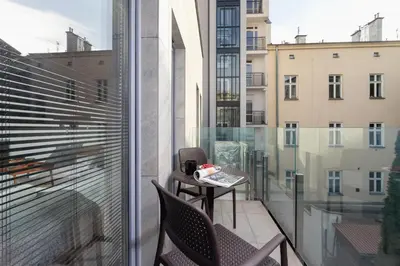 a balcony with a table and chairs on a balcony at Studio apartment - Rakowicka 14 Street in Kraków