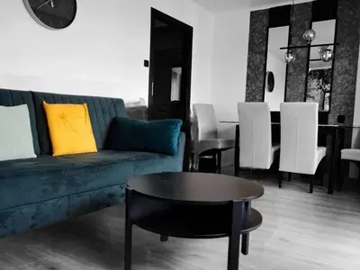 a living room with a blue couch and a table at Green apartament 2 in Oświęcim
