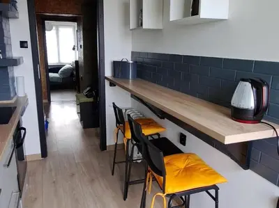 a living room with a couch and a table with chairs at Green apartament 2 in Oświęcim
