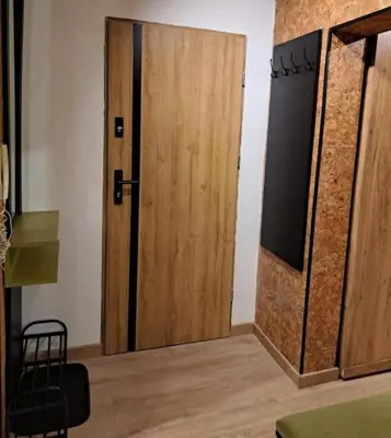 a kitchen with a counter with four stools at Green apartament 2 in Oświęcim