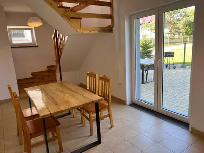 a dining room with a wooden table and chairs at Domek Olivia na Wyłączność in Wola Kalinowska
