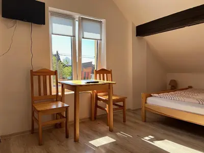 a bedroom with a table and chairs and a bed and a window at Domek Olivia na Wyłączność in Wola Kalinowska