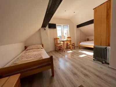 a bedroom with two beds and a table and chairs at Domek Olivia na Wyłączność in Wola Kalinowska