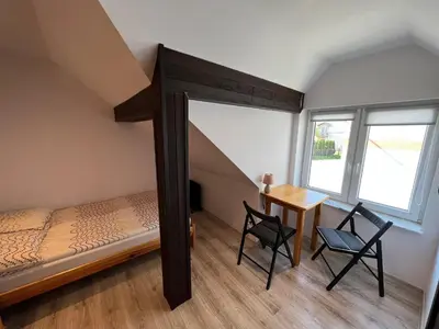 a bedroom with a bed and two chairs and a table at Domek Olivia na Wyłączność in Wola Kalinowska