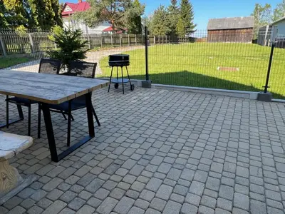 a picnic table and a grill on a brick patio at Domek Olivia na Wyłączność in Wola Kalinowska