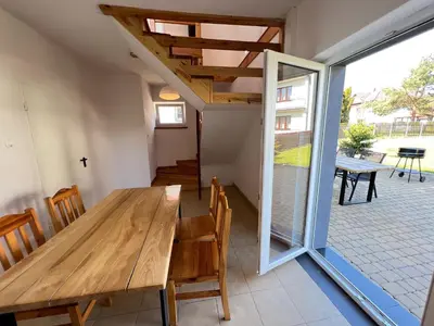 a dining room with a wooden table and chairs at Domek Olivia na Wyłączność in Wola Kalinowska