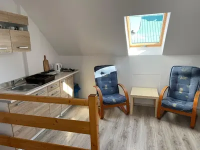 a kitchen with two blue chairs and a sink at Domek Olivia na Wyłączność in Wola Kalinowska
