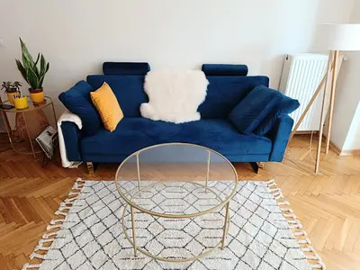 a blue couch with a glass table in a living room at Coco Chanel Cosy 45 m2 city centre fast wifi in Kraków