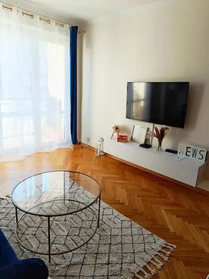 a living room with a table and a flat screen tv at Coco Chanel Cosy 45 m2 city centre fast wifi in Kraków