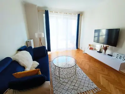 a living room with a blue couch and a glass table at Coco Chanel Cosy 45 m2 city centre fast wifi in Kraków