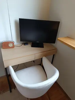 a desk with a computer monitor and a white chair at Coco Chanel Cosy 45 m2 city centre fast wifi in Kraków