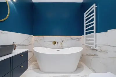 a bathroom with a white tub and a blue wall at Apartment - Plac Wolnica 12A in Kraków