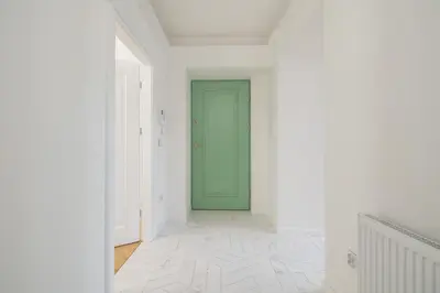 a hallway with a green door and white walls at Apartment - Plac Wolnica 12A in Kraków