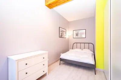 a small bedroom with a bed and a dresser at RentPlanet - Apartament Ariańska in Kraków