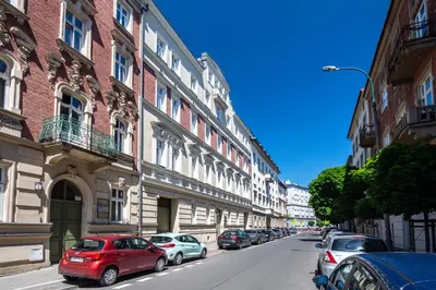 a street with cars parked on the side of a building at RentPlanet - Apartament Ariańska in Kraków