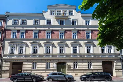 a large building with cars parked in front of it at RentPlanet - Apartament Ariańska in Kraków