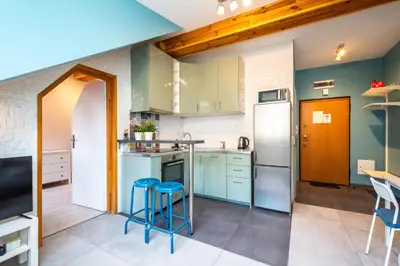 a kitchen with white appliances and blue stools at RentPlanet - Apartament Ariańska in Kraków