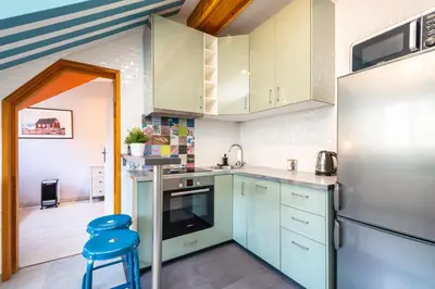a kitchen with blue cabinets and a blue stool at RentPlanet - Apartament Ariańska in Kraków