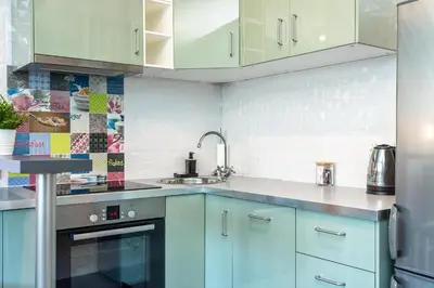 a kitchen with blue cabinets and a sink at RentPlanet - Apartament Ariańska in Kraków