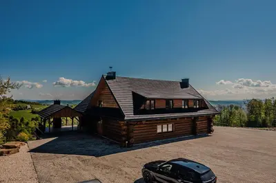 a house with a car parked in front of it at Dom z bali - Serafinówka in Tęgoborze