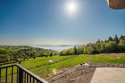a view of a green field from a balcony at Dom z bali - Serafinówka in Tęgoborze