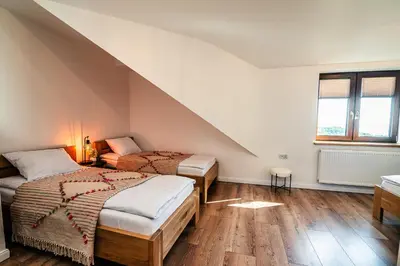 two beds in a room with an attic at Dom z bali - Serafinówka in Tęgoborze