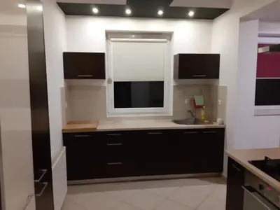 a kitchen with black cabinets and a window at Apartament Kantego in Olkusz