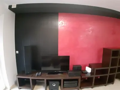a living room with a red wall and a television at Apartament Kantego in Olkusz
