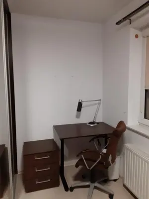 a desk with a lamp and a chair in a room at Apartament Kantego in Olkusz
