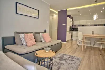 a living room and kitchen with a couch and a table at Komfortowy Apartament Bociana 4 in Kraków