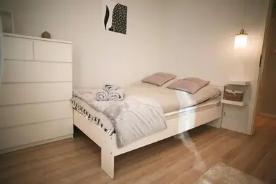 a bedroom with a white bed and a dresser at Komfortowy Apartament Bociana 4 in Kraków