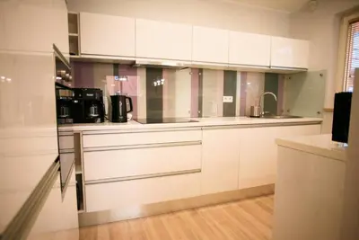 a kitchen with white cabinets and a sink at Komfortowy Apartament Bociana 4 in Kraków