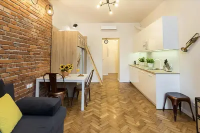 a kitchen and a living room with a table in a room at Studio apartment - Centre of Kraków - Starowiślna 54 in Kraków