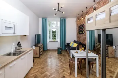 a kitchen and a living room with a table at Studio apartment - Centre of Kraków - Starowiślna 54 in Kraków