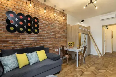 a living room with a couch and a brick wall at Studio apartment - Centre of Kraków - Starowiślna 54 in Kraków