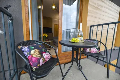 a table and two chairs on a balcony at Sunshine by Housine in Zator