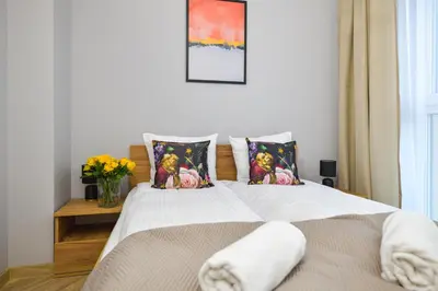a bedroom with a bed with a vase of flowers at Sunshine by Housine in Zator