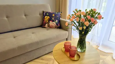 a living room with a couch and a table with a vase of flowers at Sunshine by Housine in Zator
