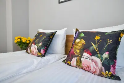 a bed with two pillows and a bird on it at Sunshine by Housine in Zator